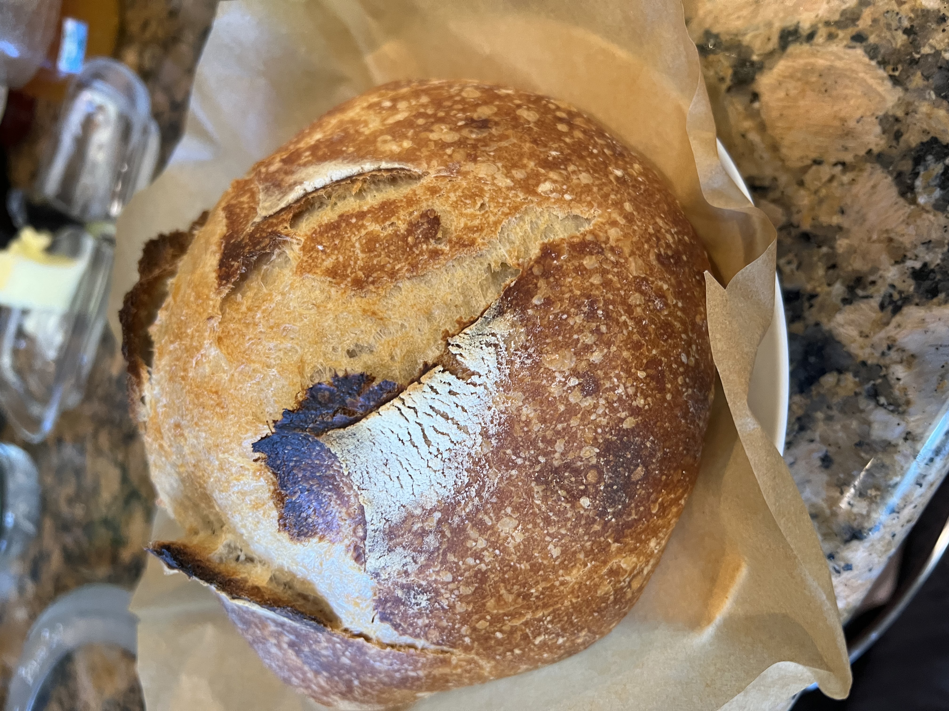 A homemade sourdough loaf with a golden, flour-dusted crust